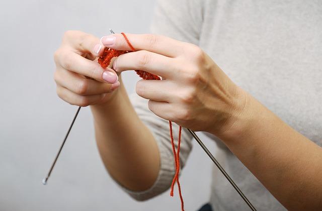 a lady beginning to learn to knit with a beginners guide